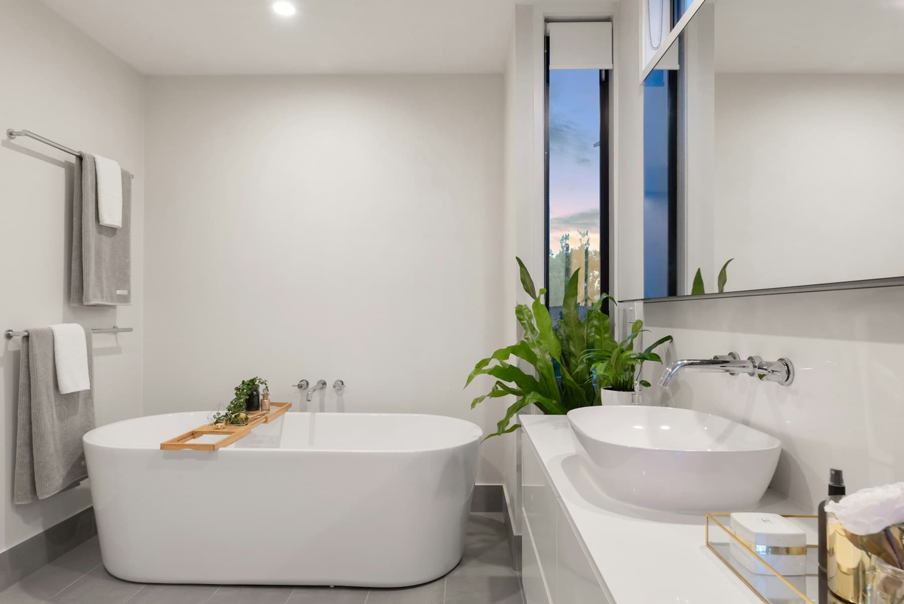 Baño de tonos claros con lavabo, espejo y acabados naturales